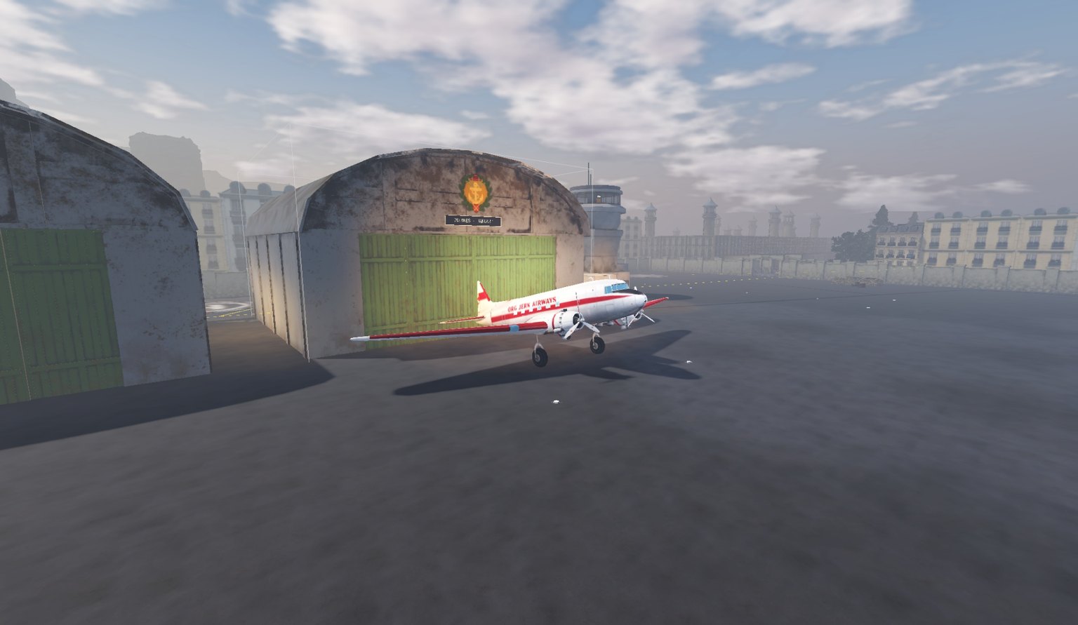 The DC3 on the Toulouse apron, small beside the hangar